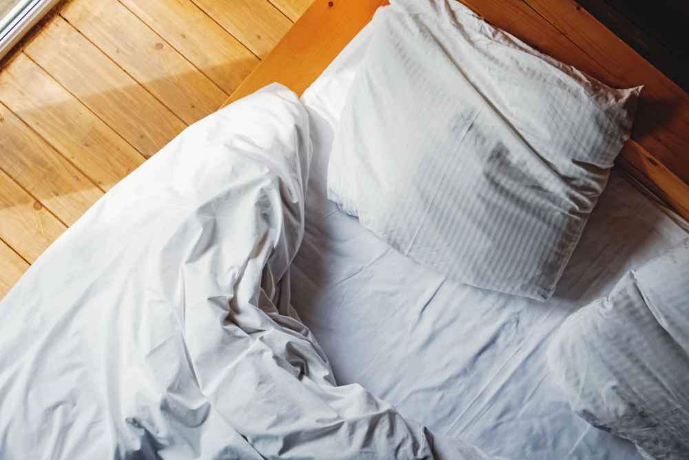 crumpled bedsheets with pillow