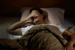 insomnia man trying to sleep in bed