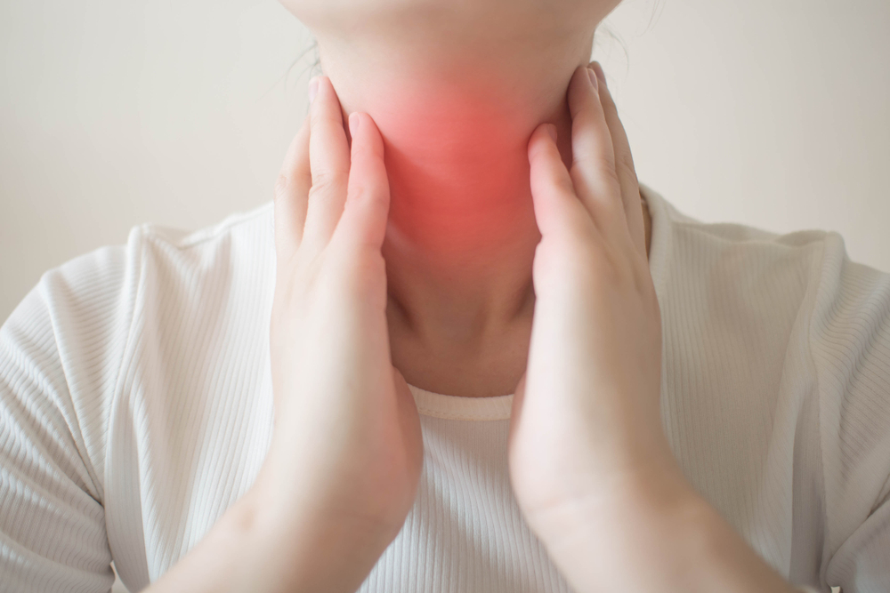 Asian woman touch thyroid gland graves' disease