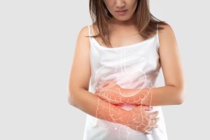 crohn's disease, asian woman holding abdomen