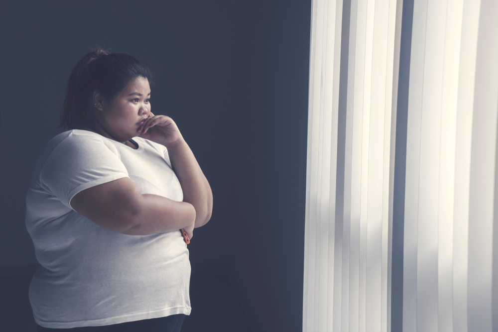 obesity asian woman looking out of window contrave (naltrexone / bupropion)