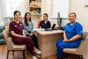 HLC team photo with Dr Wang seated in darker blue scrubs from right hand