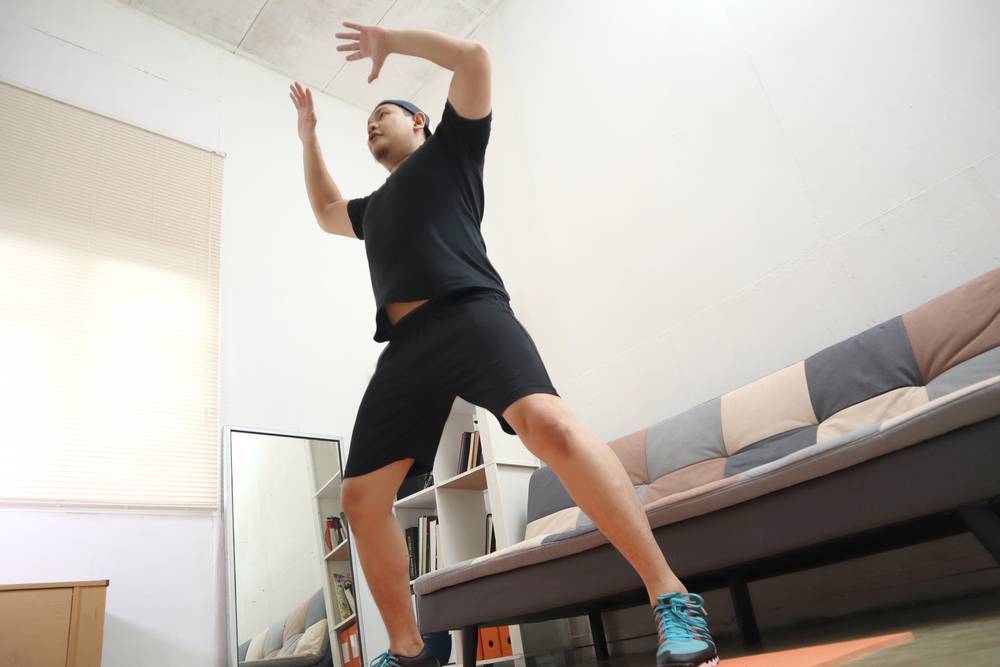 Man doing jumping jacks at home