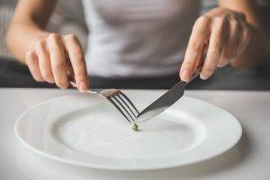 fork and knife cutting pea on white plate