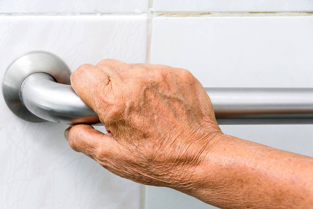 elderly hand holding grab bar