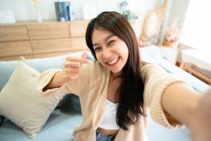 Pretty,Young,Asian,Female,With,Big,Smile,Sitting,At,Living