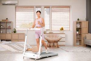 Sporty,Asian,Woman,With,Headphones,And,Mobile,Phone,Training,On