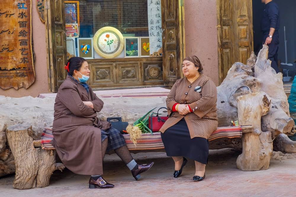 Kashgar,xinjiang,china march,13,,2023:two,Uyghur,Women,Sit,On,Stools,In,The,Streets