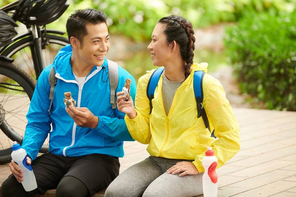 Happy,Young,Couple,Eating,Energy,Bars,After,Bicycle,Ride,To